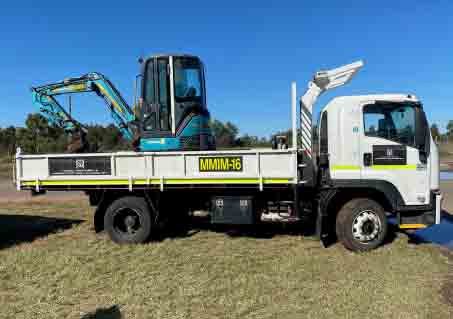 Six-wheeler truck carrying a 3.5T excavator - MM & IM Local Infrastructure Mangement Specialist